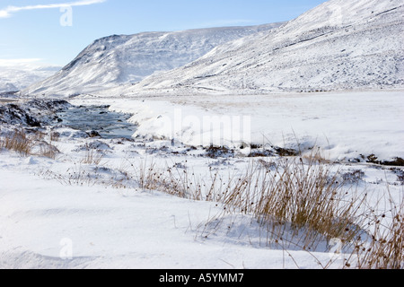 Glen Clunie eau sur la route de Glenshee, rives enneigées et rivière gelée, Braemar près de la route A93 vers Glenshee, Écosse Royaume-Uni Banque D'Images
