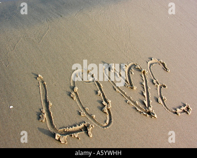 Message écrit sur l'amour sur une plage de sable Banque D'Images