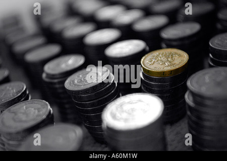 Des piles de pièces d'une livre anglaise en noir et blanc avec une pile en couleur. Banque D'Images