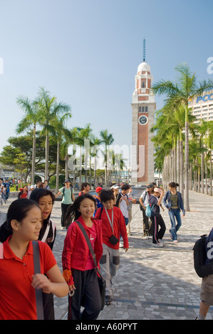 Les enfants de l'école à l'ancienne tour de l'horloge vestige colonial sur la Tsim Sha Tsui promenade au bord de l'extrémité de Nathan Road, Hong Kong Banque D'Images