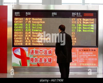 Chinese man reading départ de vol à destination d'embarquement en aéroport de Chengdu, province du Sichuan, Chine. Banque D'Images