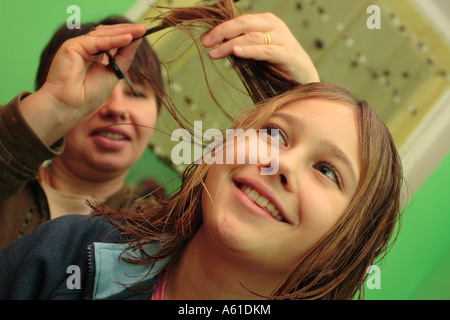 Jeune fille ayant fait couper les cheveux par sa mère à la maison Banque D'Images