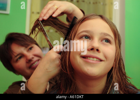 Jeune fille ayant fait couper les cheveux par sa mère à la maison Banque D'Images