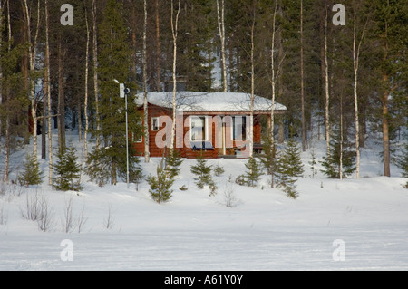 Maison de vacances chalet en bois le long de la rivière gelée, Luosto, Laponie, Finlande, Europe du Nord, de l'Arctique Banque D'Images