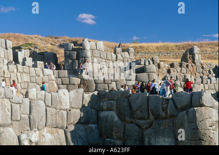 Amérique du Sud PÉROU Cusco Sacsayhuman personnes marchant le long de la partie supérieure de l'Inca de murs en pierre Banque D'Images