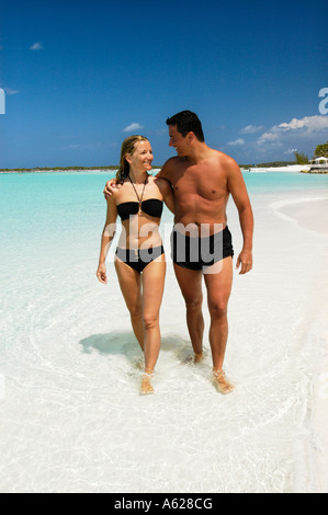 Couple en train de marcher sur une plage de sable blanc tropicales. Banque D'Images