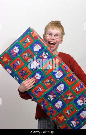 Portrait d'un petit garçon heureux avec un grand cadeau de Noël Banque D'Images