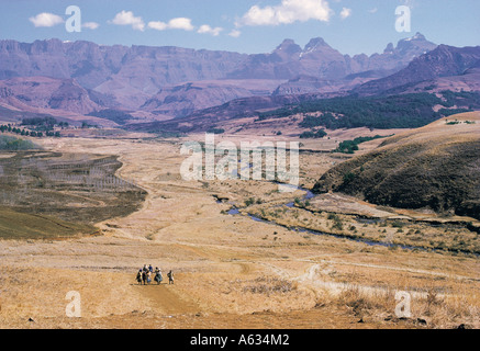 Les femmes africaines et les enfants dans une vallée avec le géant s Château et les montagnes du Drakensberg Natal Afrique du Sud Banque D'Images