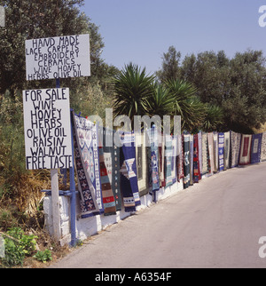 Fabrication locale traditionnelle des tapis et carpettes exposés à la vente sur mur en bordure de village Volimes Zakynthos Island Les îles Grecques Banque D'Images