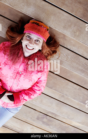 High angle view of a young woman lying on marches de bois Banque D'Images