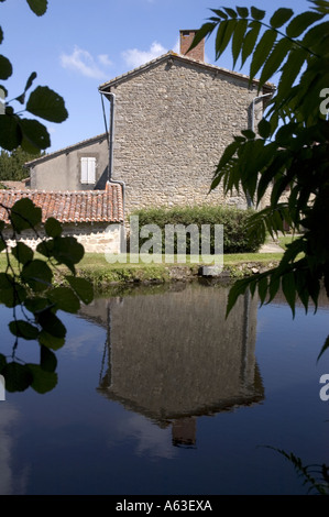 Une vue tranquille sur le lac d'une ancienne maison de village dans le village de Mortemart dans la région du Limousin Banque D'Images