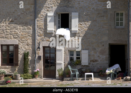 Une maison à Mortemart France sortir le couvre-lit à l'air dans la douce brise sur une belle journée d'été Banque D'Images