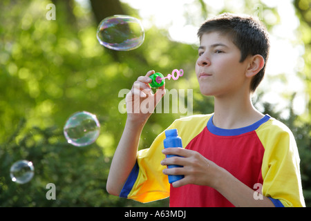 Portrait d'un jeune garçon qui fait des bulles de savon Banque D'Images
