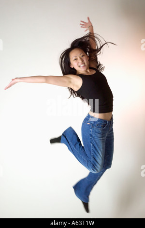 Une jeune femme asiatique saute de joie Banque D'Images