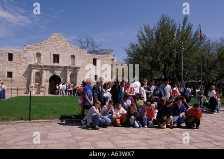 Groupe scolaire s'agenouille devant l'Alamo pour photo de classe San Antonio Texas Banque D'Images