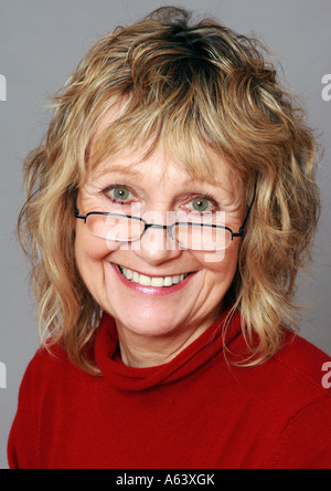 Smiling soixante-année-vieille femme portant des lunettes Banque D'Images