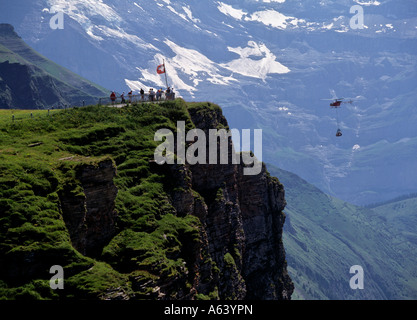 Les randonneurs au point de vue de l'alp mont männlichen regardant hélicoptère avec charge de fret de la région Rhône alpes Suisse swiss highland Banque D'Images