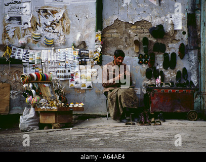 L'Iran Téhéran shoemaker dans le bazar de la réparation la réparation des chaussures chaussures boutique de vente de chaussures d'affaires locales indigènes commerciales Banque D'Images