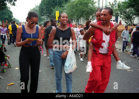 Group walking down street sur chemin de festival de Notting Hill Banque D'Images