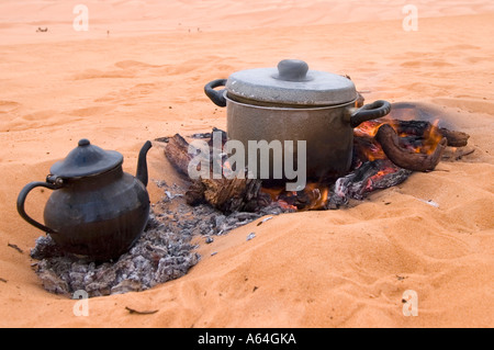 Le dîner et le thé la cuisson sur un feu dans le sable, la Libye Banque D'Images