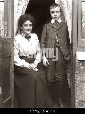 Portrait d'une mère de style édouardien avec son fils à la porte de leur maison Banque D'Images