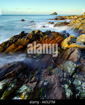 Belle aube lumière à wembury plage avec la mer au cours de la cascade et rochers exposés le mew stone à l'horizon Banque D'Images