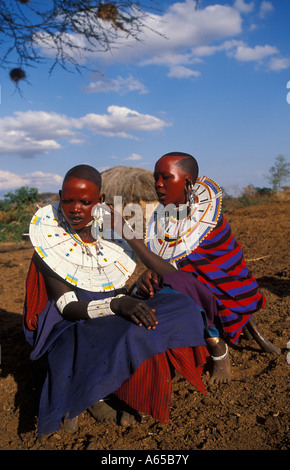 Les femmes masaï peindre leurs visages d'ocre rouge en préparation d'une cérémonie Longido Tanzanie Banque D'Images