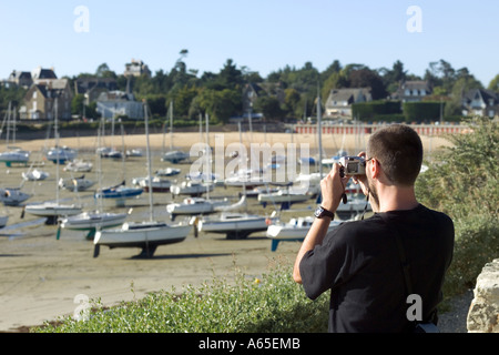 L'HOMME À PRENDRE DES PHOTOS DE BATEAUX À MARÉE BASSE SAINT-BRIAC-SUR-MER COVE BRETAGNE FRANCE Banque D'Images