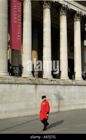 Chelsea retraité en manteau rouge passant la National Gallery à Trafalgar Square London Banque D'Images