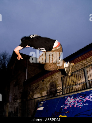 18-ans femme faisant aggressive inline skating astuces dans UK skatepark Banque D'Images