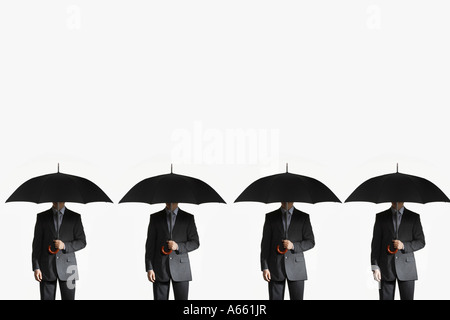 Les hommes d'affaires des parasols, standing side by side Banque D'Images