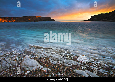 Coucher de soleil sur la baie circulaire de Lulworth Cove, à Dorset Banque D'Images