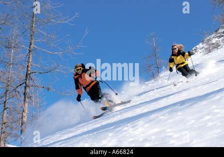 L'homme et la femme ski dans les arbres de la glisse en France Banque D'Images