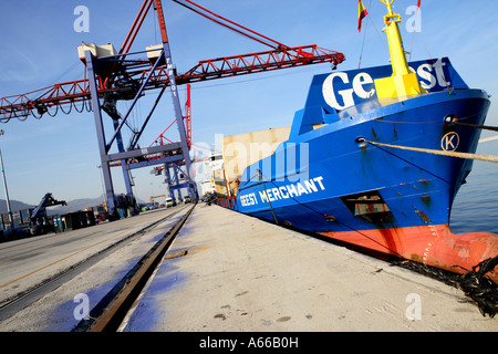 Un grand navire attend d'être débarqué dans un port occupé Banque D'Images