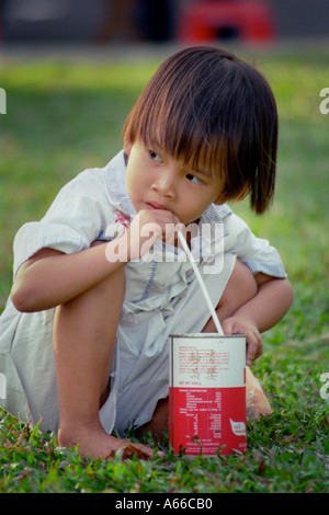 Jeune fille vietnamienne prend une gorgée de lait un peut à Ho Chi Minh City Vietnam Banque D'Images