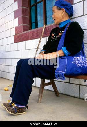 Vieille Femme avec lié pieds assis sur un banc .Yunnan, en Chine. Voir également Alamy ref A66A66EHY et EJH Banque D'Images