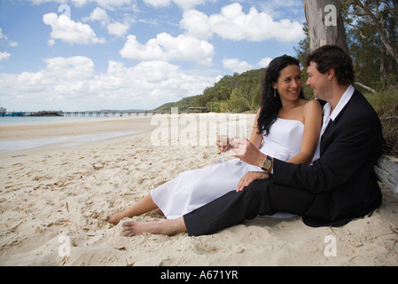 Un couple profitez d'un verre sur la plage à Kingfisher Bay sur l'île Fraser Banque D'Images