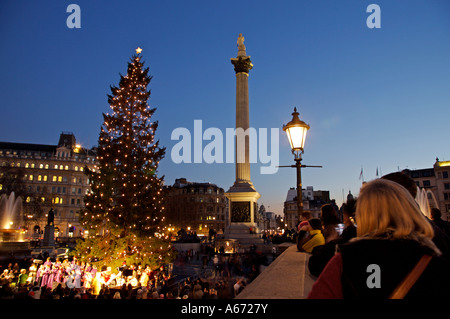 Passants profitez des chants de Noël à Trafalgar Square Banque D'Images