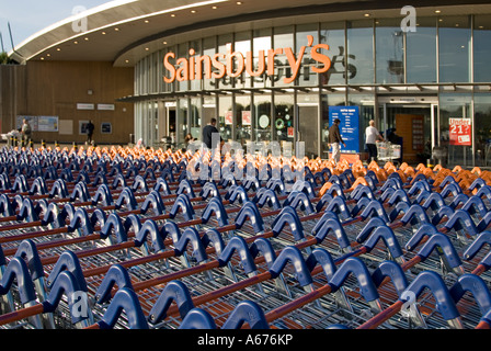 Grande concentration de chariots de supermarché Sainsburys en face de l'entrée du magasin Banque D'Images