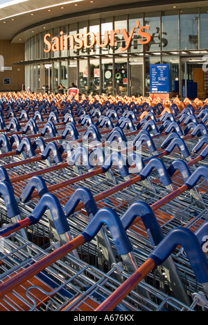 Grande concentration de chariots de supermarché Sainsburys en face de l'entrée du magasin Banque D'Images