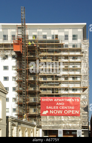 Site de construction de bâtiments Travaux les échafaudages et la conversion de bureaux en appartements bannières publicitaires montrent apartment & sales center Essex England UK Banque D'Images