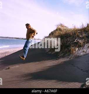 Homme de sauter à la plage des dunes Banque D'Images