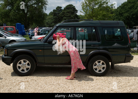 Femme se préparant à vérifier son chapeau dans le miroir de voiture Royal Ascot Berkshire Angleterre des années 2006 2000 UK HOMER SYKES Banque D'Images