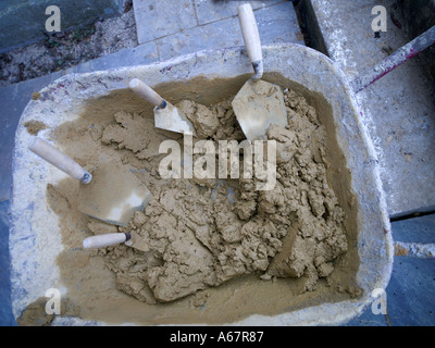 4 trowls dans une brouette pleine de ciment Banque D'Images