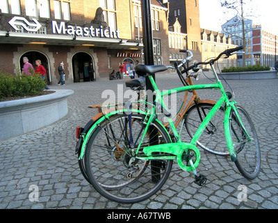 Deux vélos verrouillé sur un lampadaire en face de la gare de Maastricht Pays-Bas Banque D'Images