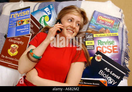 Teenage girl student talking on telephone n'étudie pas ses devoirs dans la chambre Banque D'Images