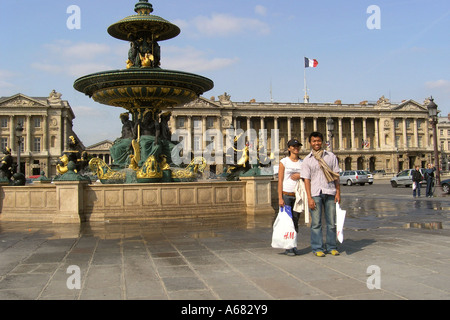 Couple asiatique pour l'instantané en face de fontaine sur la Place de la Concorde Paris France Banque D'Images