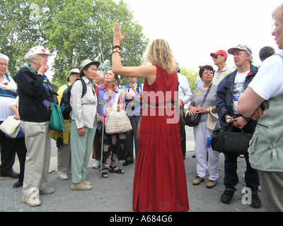 Dame en rouge chargeant groupe de touristes à Notre Dame Paris France Banque D'Images