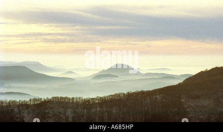 Brouillard d'hiver est une image couleur à plus de collines enneigées lorsque le soleil se couche Banque D'Images