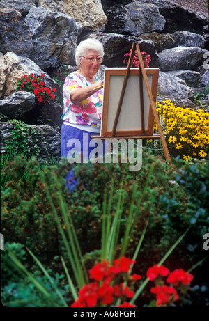 Senior woman painting in a garden Banque D'Images